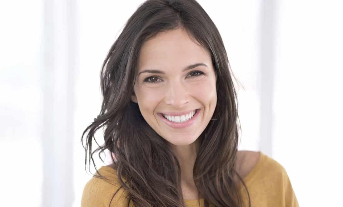 Photo of young women in yellow top wear standing on white background